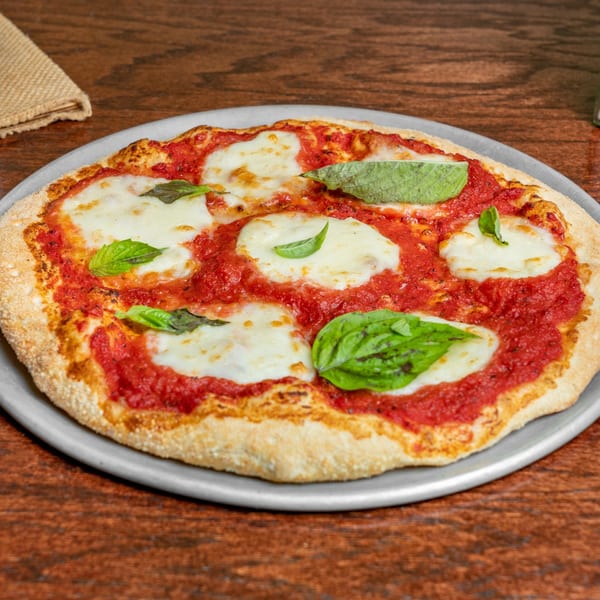 A freshly baked Margherita pizza with vibrant red sauce, melted mozzarella, and fresh basil leaves.